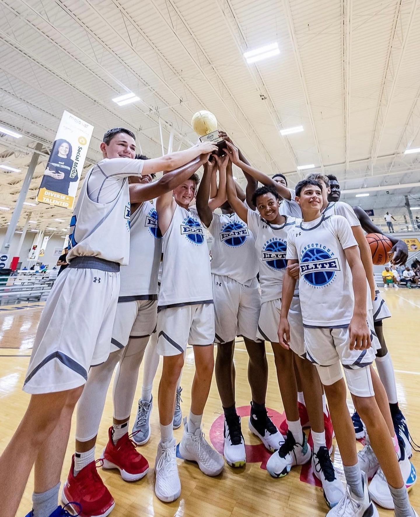 Connecticut Elite players hoisting a championship trophy at a showcase